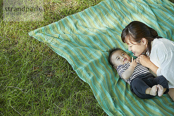 Japanische Mutter kuschelt mit ihrem Baby