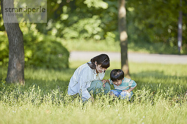 Japanische Eltern und Kinder spielen im Park