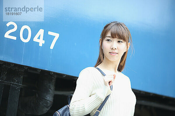 Japanerin steht neben einem Zug