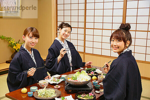 Japanische Frauen essen in einem Gasthaus mit heißen Quellen zu Abend