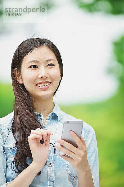 Japanerin mit einem Mobiltelefon