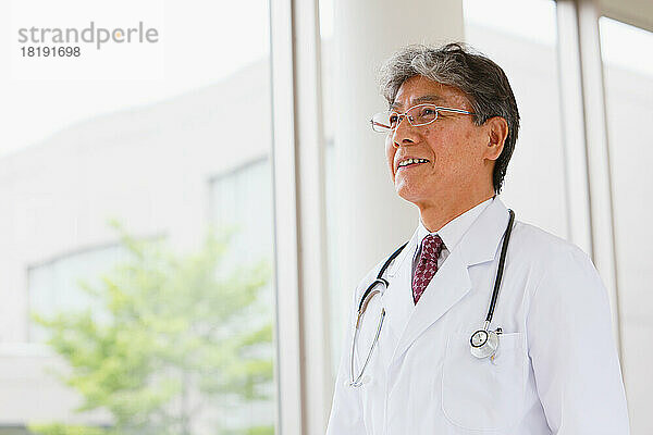 Lächelnder japanischer Arzt im Flur