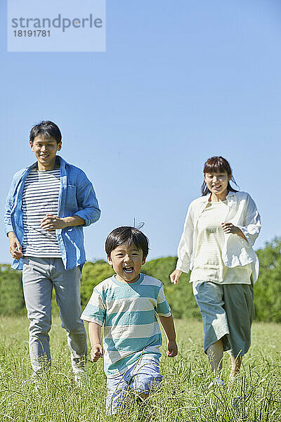 Japanische Familie läuft auf dem Feld