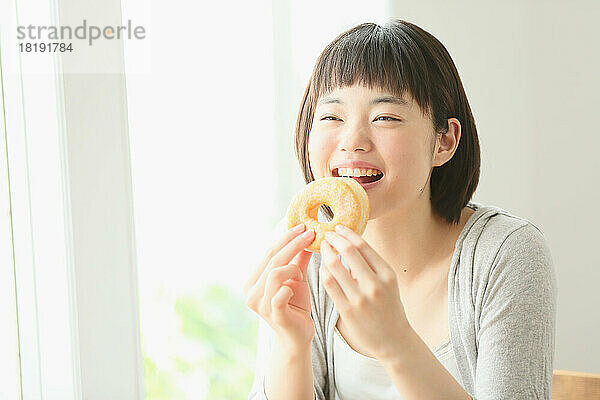 Junge Japanerin isst einen Donut