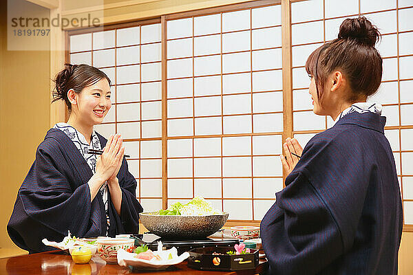 Japanische Frauen essen in einem Gasthaus mit heißen Quellen zu Abend