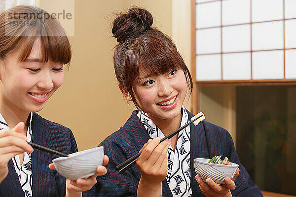 Japanische Frauen essen in einem Gasthaus mit heißen Quellen zu Abend