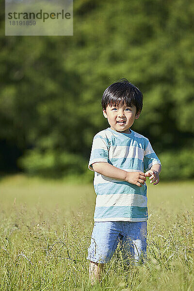 Lächelnder japanischer Junge auf dem Feld
