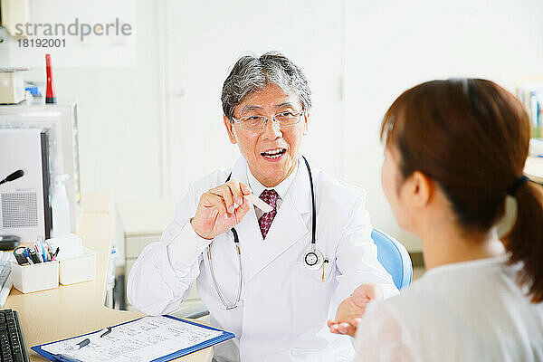 Japanische Frau wird von einem Arzt untersucht