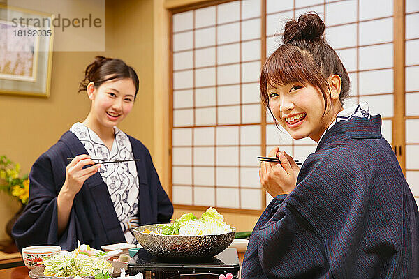 Japanische Frauen essen in einem Gasthaus mit heißen Quellen zu Abend