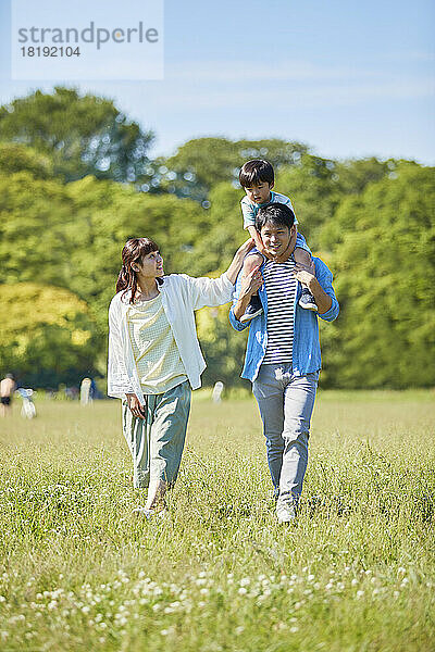 Japanische Familie geht im Park spazieren