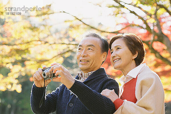 Älteres japanisches Paar  das in der Herbstlaubsaison reist