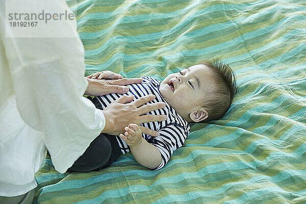 Japanische Mutter gibt Baby eine Massage