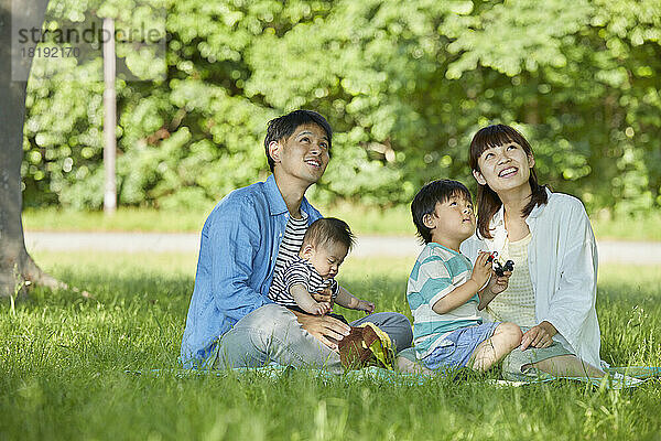 Japanische Familie entspannt auf dem Rasen