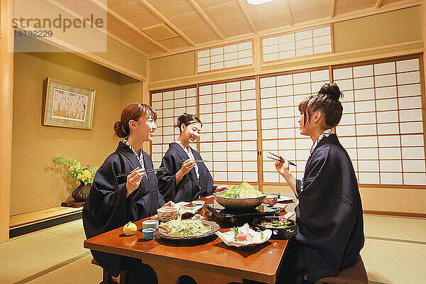 Japanische Frauen essen in einem Gasthaus mit heißen Quellen zu Abend
