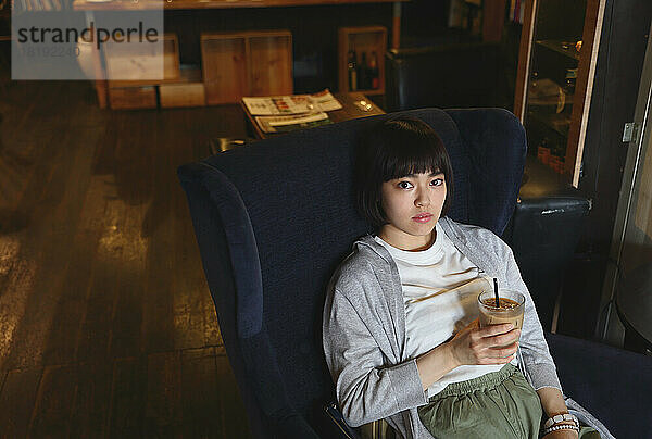 Junge Japanerin entspannt sich in einem Café