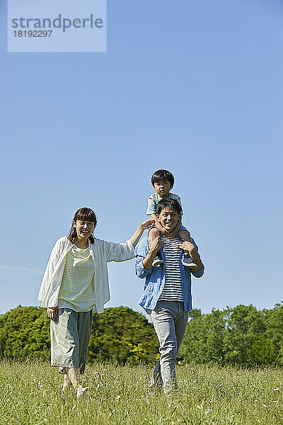 Japanische Familie geht auf dem Feld spazieren