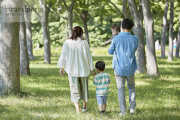 Japanische Familie spaziert durch frisches Grün
