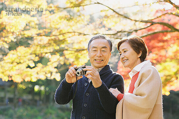 Älteres japanisches Paar  das in der Herbstlaubsaison reist
