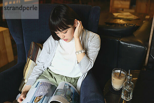 Junge Japanerin entspannt sich in einem Café