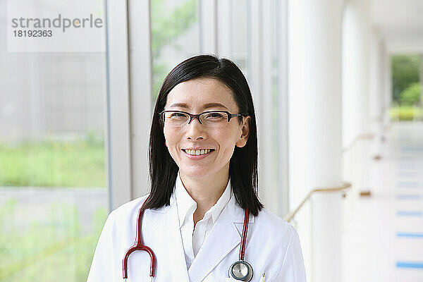Lächelnder japanischer Arzt im Flur