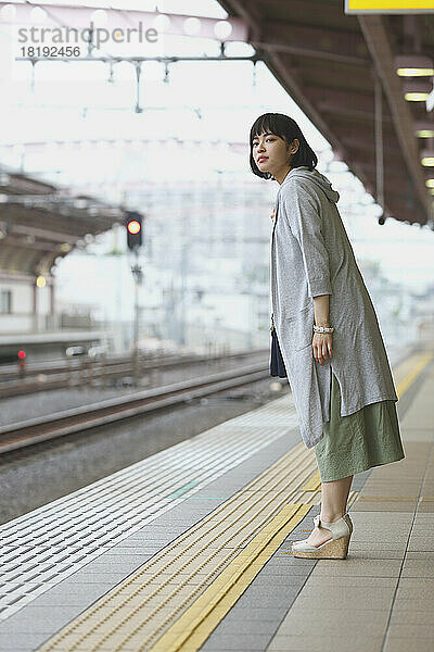 Junge Japanerin auf einem Bahnsteig