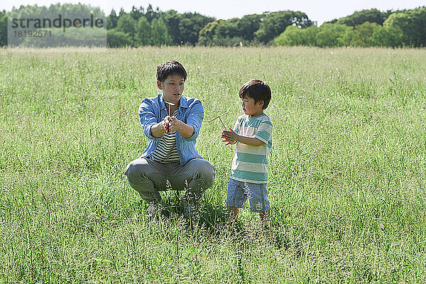 Japanische Eltern und Kinder spielen mit Bambuskopter