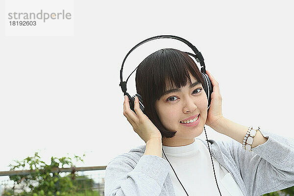 Junge Japanerin hört Musik mit Kopfhörern