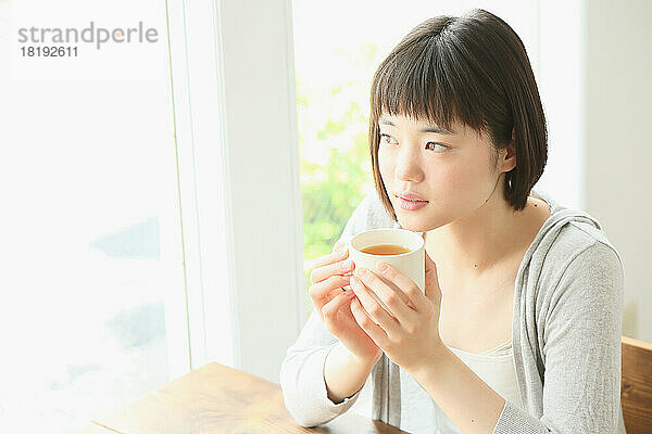Junge Japanerin trinkt Tee