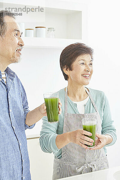 Japanisches Seniorenpaar trinkt grünen Saft