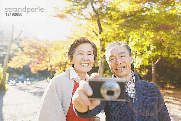 Älteres japanisches Paar  das in der Herbstlaubsaison reist