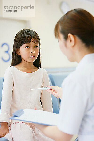 Japanisches Mädchen misst Fieber