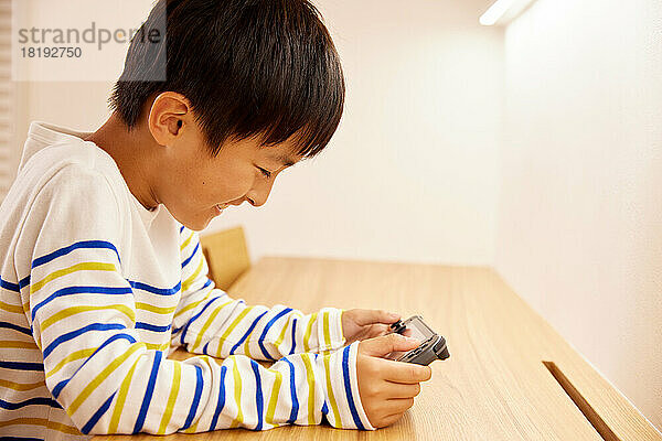 Japanisches Kind spielt zu Hause Spiele