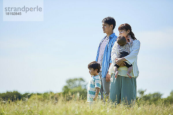 Japanische Familie mit einem Lächeln und blauem Himmel im Hintergrund