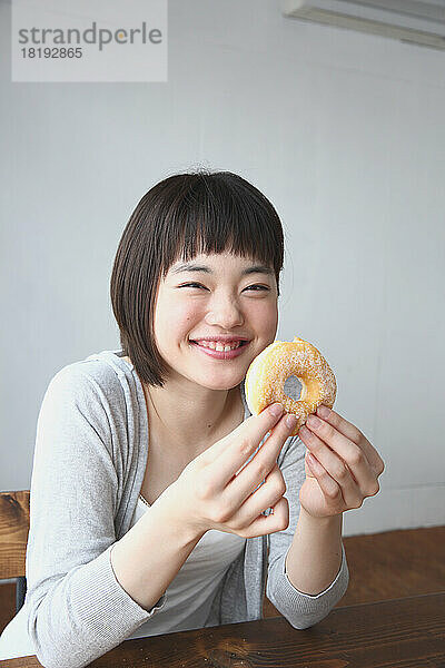 Junge Japanerin isst einen Donut