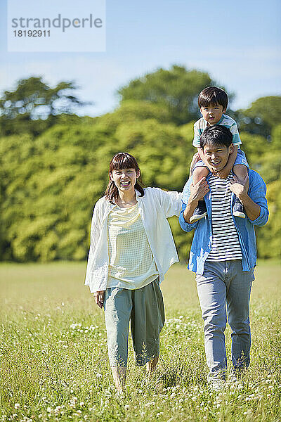 Japanische Familie geht im Park spazieren