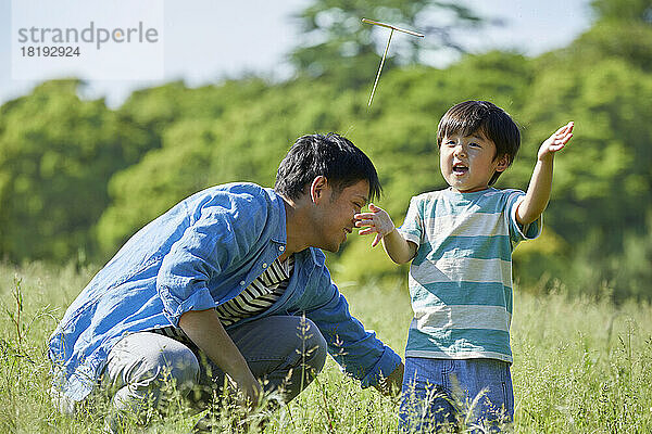 Japanische Eltern und Kinder spielen mit Bambuskopter