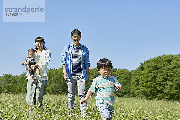 Japanische Familie macht einen Spaziergang auf dem Feld