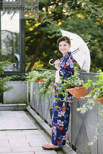 Japanerin in einem Yukata mit Sonnenschirm