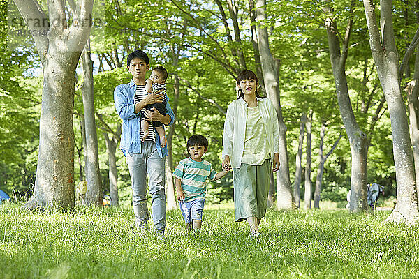 Japanische Familie spaziert durch frisches Grün