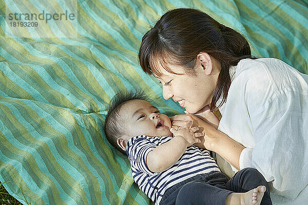 Japanische Mutter kuschelt mit ihrem Baby