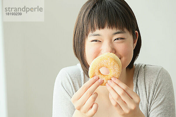 Junge Japanerin isst einen Donut