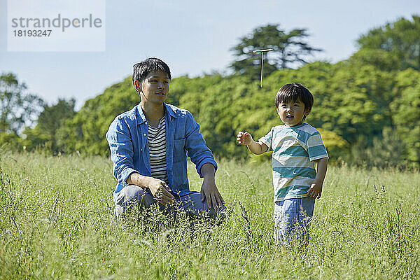 Japanische Eltern und Kinder spielen mit Bambuskopter