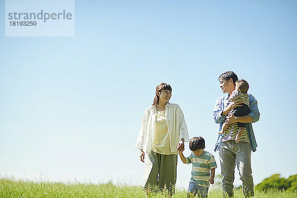 Blauer Himmel und lächelnde japanische Familie
