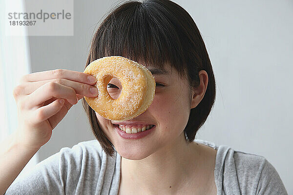 Junge Japanerin hält einen Donut