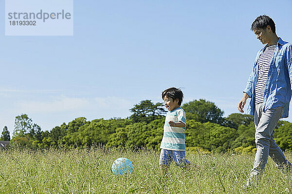 Japanische Eltern und Kinder spielen mit einem Ball