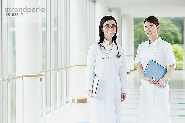 Lächelnder Arzt und junge Krankenschwester im Flur