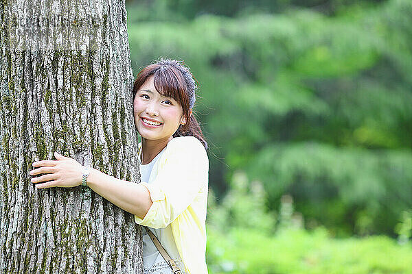 Japanerin umarmt einen Baum