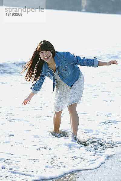 Junge Japanerin hat Spaß am Strand