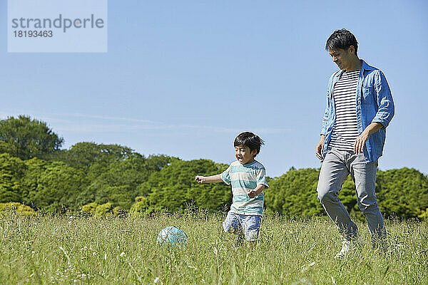 Japanische Eltern und Kinder spielen mit einem Ball