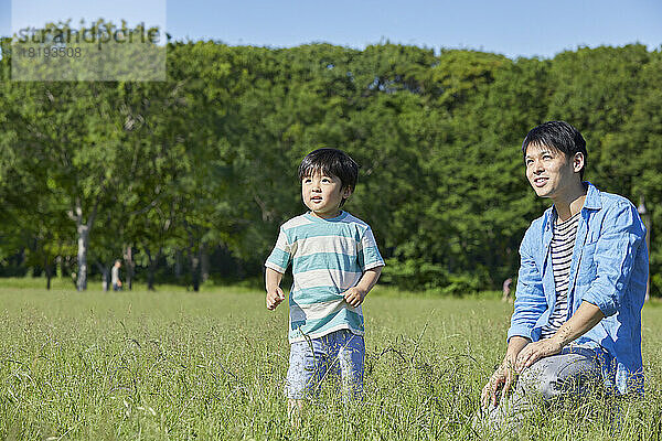 Japanische Eltern und Kinder spielen im Park